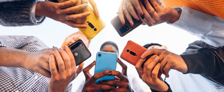 An array of colorful smartphones held by people, highlighting the tech devices at risk of identity fraud