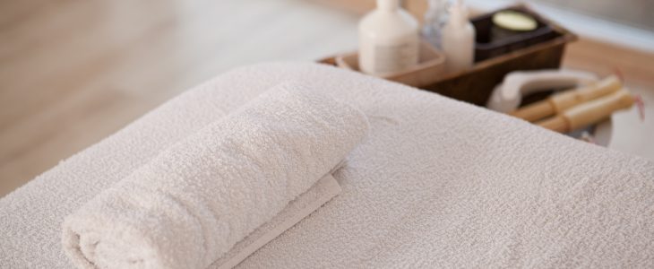 White towels rolled on massage table