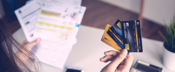 Woman holding credit cards and financial statements